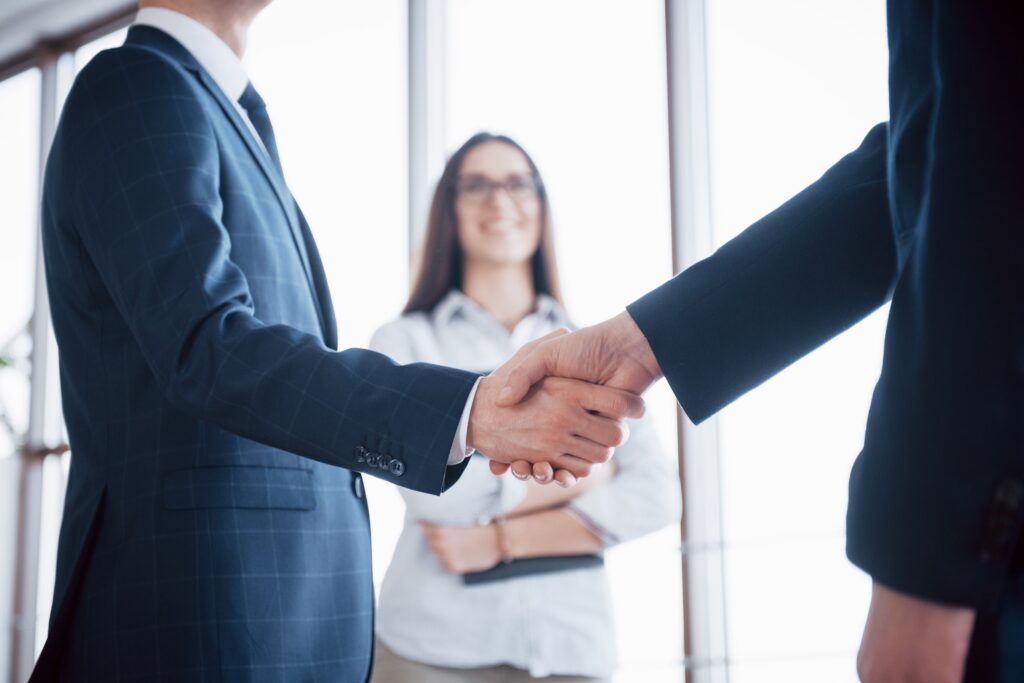 Two business professionals shaking hands, representing a successful BRG client partnership